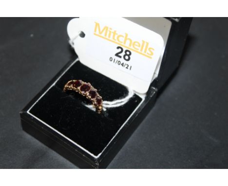 A gold coloured metal (thought 9ct), and garnet set ring of Victorian design, the textured shank set with five graduated oval