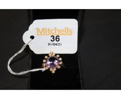 A coloured metal amethyst and seed pearl ring of Victorian design, the oval cushion cushion cut amethyst approx 4 ct, ring si