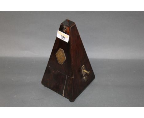 An antique stained wood cased metronome, with applied brass plaque to fascia.  Height 23 cm (slight damage to front).