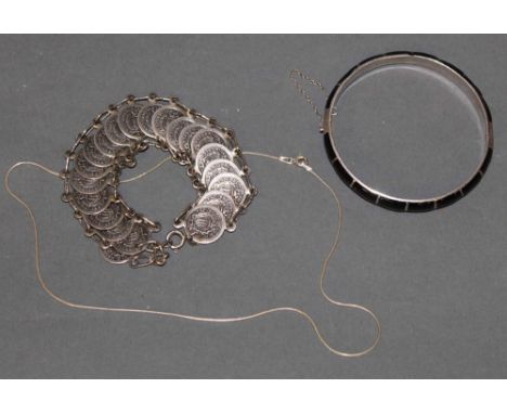 A Thai black enamelled silver bangle, 7 cm diameter, a white metal bracelet formed of San Marino Coins and a silver neck chai