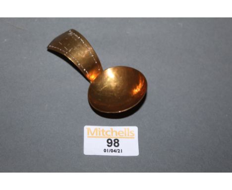 A late 19th century hammered brass caddy spoon of KSIA design, with circular bowl and angled terminal, 8 cm long 