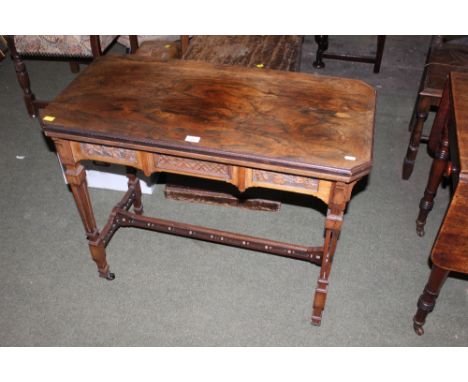 A late Victorian rosewood rectangular card table of aesthetic design, the green baize line folding top with canted corners on