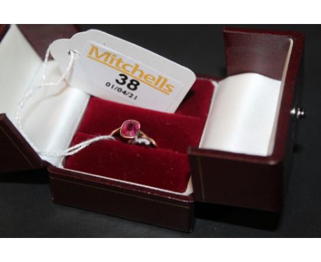 A 9ct gold and deep pink stone (possibly Ruby), the rectangular colette set cushion cut stone approx 0.4 carats, ring size P 