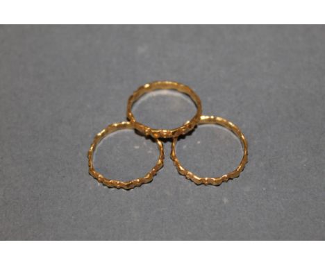 A set of three eastern gold coloured metal (thought higher carat gold) stacking rings of geometric design, ring size M, combi