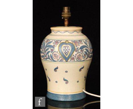 A Bursley Ware table lamp base designed by Charlotte Rhead decorated with scrolls, stylised leaves and hearts against a pale 