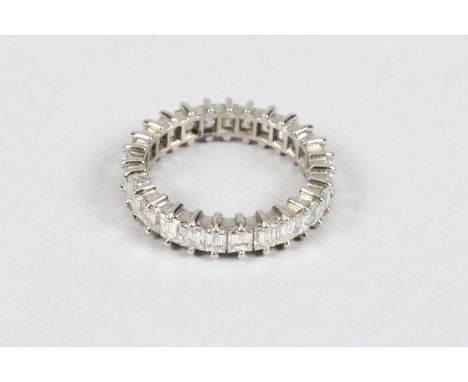 Ladies diamond eternity ring, unmarked white metal with .25 emerald cut diamonds and a single baggette cut diamond 