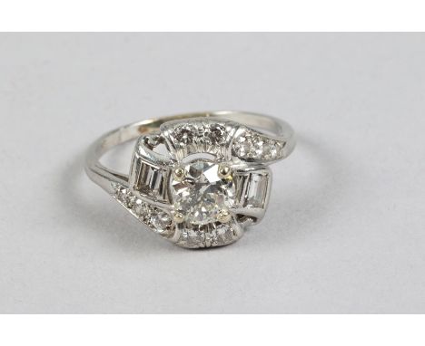 Platinum diamond cluster ring, .75 carat brilliant cut diamond with an emerald cut diamond set either side and five brilliant