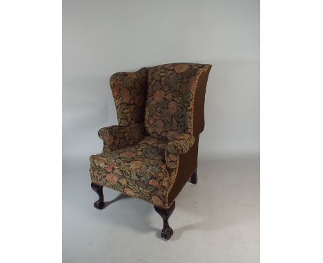 A 19th Century Tapestry Upholstered Wing Armchair on Claw and Ball Front Feet. 