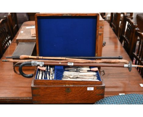 An antique brass-bound oak canteen by Army &amp; Navy, containing a mixed selection of Victorian and later ep flatware and cu