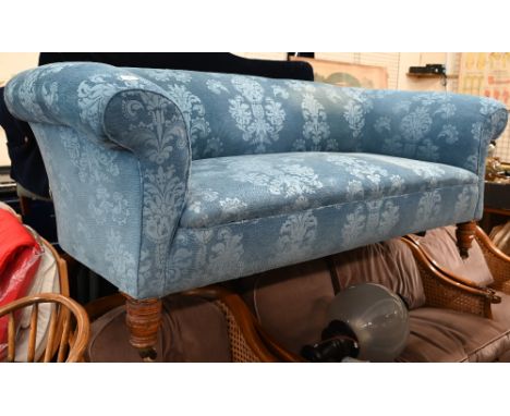 An Edwardian traditional Chesterfield sofa in foliate pattern blue fabric with ring turned front legs and allround casters, 1