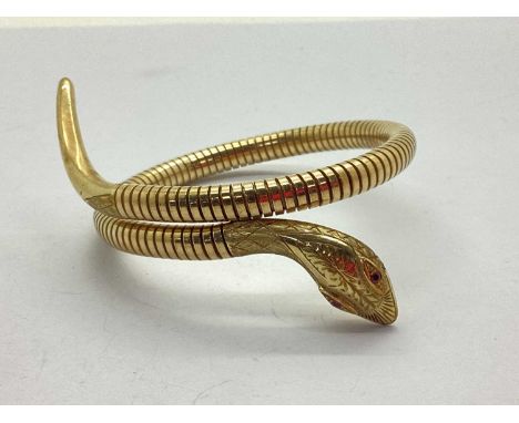 A 9ct Gold Articulated Wrap Around Serpent Bangle, the highly decorative head with stone set eyes and stamped "STEEL SPRING C