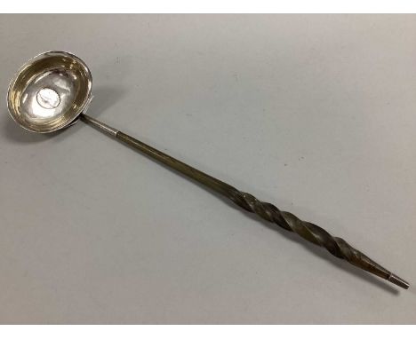 A Georgian Toddy Ladle, the oval bowl with inset coin (rubbed), twisted handle, 33cm long.