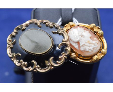 A Victorian yellow metal and black enamel brooch, engraved name to back; and a Victorian yellow metal brooch with floral moun