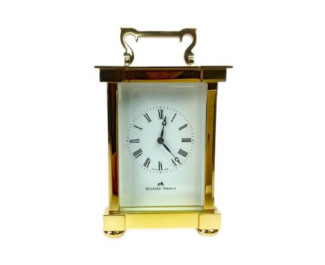 BRASS CARRIAGE CLOCK BY MATTHEW NORMAN, with two train eight day movement, the white enamel dial with Roman numerals, contain