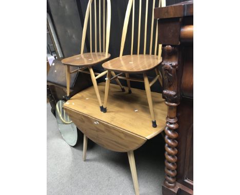 An Ercol light colour Beech and Elm dining table with six matching dining chairs including two carver chairs. The drop leaf d
