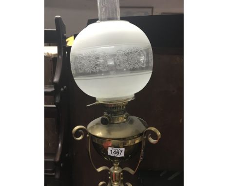 A brass telescopic standard lamp. With a glass shade.