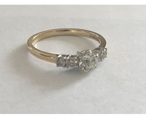 A Quality 18 carat Gold ring set with a brilliant cut diamond flanked by further diamonds. Ring size Q.