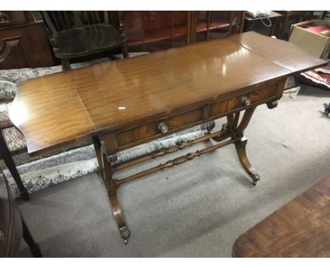 A reproduction sofa table with turned supports and raised on lion's paw feet, approx 139cm x 74.5cm x 56cm.