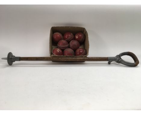 Vintage wooden shooting stick and eight vintage red cricket balls.