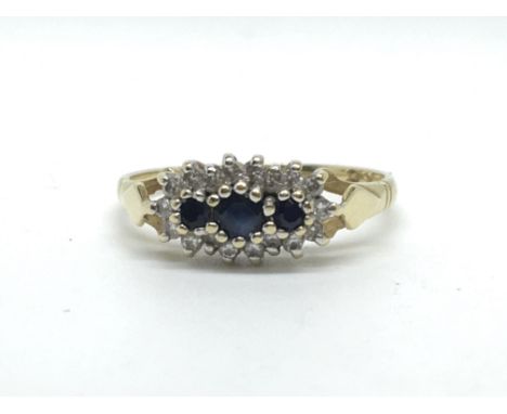 An 18ct yellow gold diamond and sapphire ring, set with three diamonds in a row surrounded by diamonds. Total weight approx 2