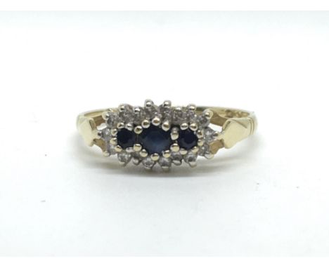 An 18ct yellow gold diamond and sapphire ring, set with three diamonds in a row surrounded by diamonds. Total weight approx 2