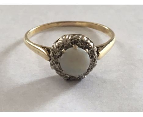 A Yellow Gold ring set with a central opal and diamonds. Ring size S.