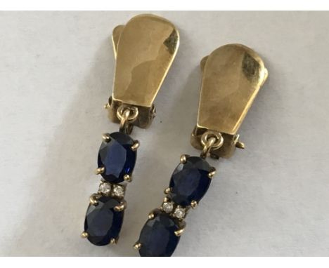 A pair of 14 carat Gold clip earrings set with blue sapphire and small diamonds.