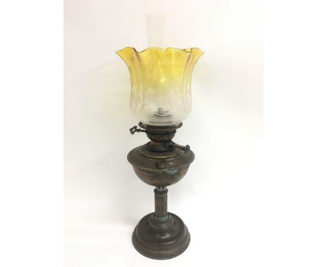 A copper oil lamp with a yellow and clear etched glass shade. Total height approximately 61cm.