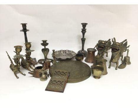 A small collection of mixed metal ware, mostly brass and copper, including candle holders in the form of mythical creatures, 