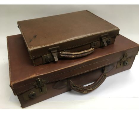 Two vintage leather suitcases.