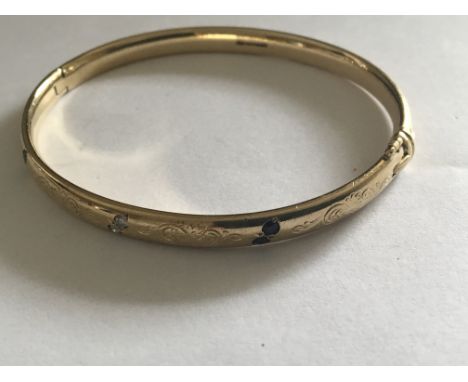 A 9 carat Gold bangle set with blue sapphire and diamonds weight 27g