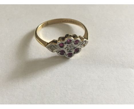 An 18 carat Gold ring set with rubies and small diamonds. Ring size P.