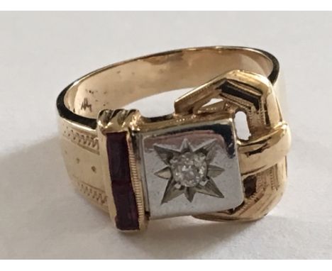 A 14carat Gold buckle ring set with a diamond and rubies. Ring size Q-R.