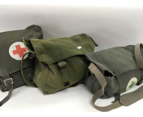 Three military first aid kit bags full of bandages, lintÕs, pads etc Red Cross and green crosses on bags.