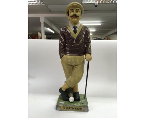 Vintage figure of a golfer advertising Dunlop golf balls.