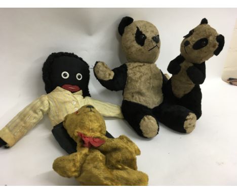 A collection of soft toys including a Golly, two Pandas, a Sooty hand puppet and others