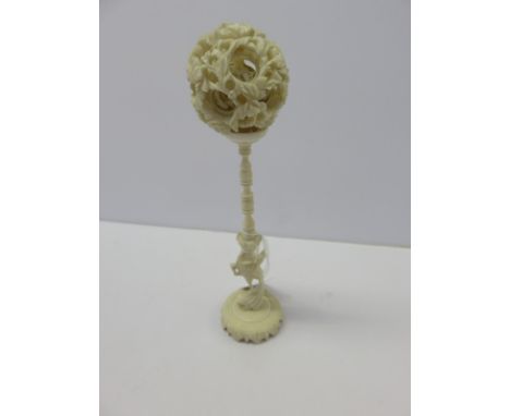 ANTIQUE IVORY, a Chinese carved ivory bird support multi tiered puzzle ball, 18" high