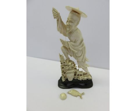 ANTIQUE IVORY CARVING, figure of a fisherman on carved hardwood stand, 7" high