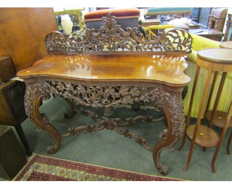 ANGLO-INDIAN CONSOLE TABLE, a rosewood topped serpentine fronted console table with ornate pierced hardwood foliate frieze ba