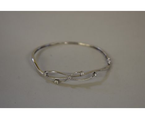 An unmarked hinged bangle,&nbsp;set five diamonds approximately .36ct. 