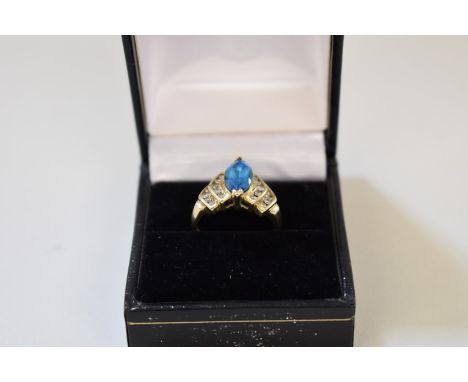 A marquis cut London blue topaz gold ring,Â&nbsp;having diamond set step shoulders, stamped 14k. 