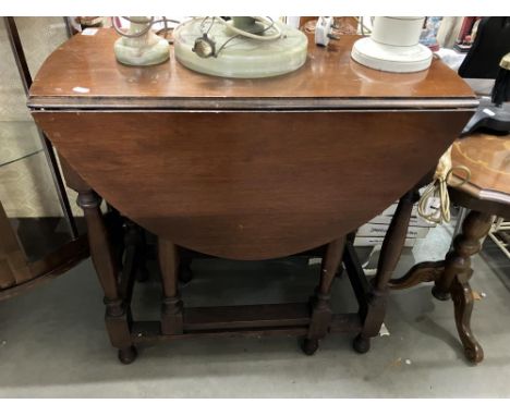 An oak dropleaf gate leg table on turned legs 