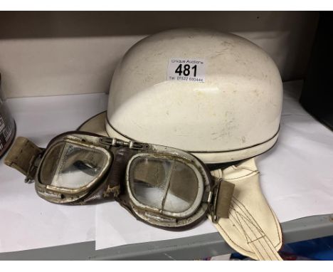 A vintage motor cycle helmet and leather backed goggles (one lens cracked ) 