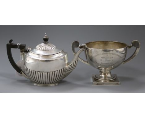 An Edwardain demi-fluted silver teapot and a later two handled silver trophy cup, gross 22 oz.