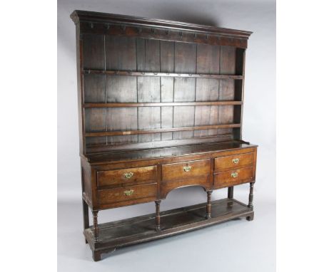 A George III oak dresser, with three shelf rack and five long drawers over a pot board, W.6ft 3in. D.1ft 3in. H.6ft 10in.