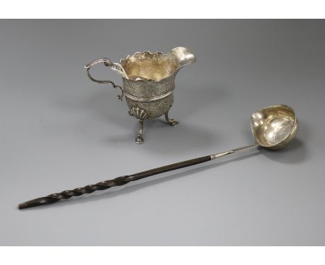 A Georgian Irish silver cream jug (a.f.) and a white metal toddy ladle.