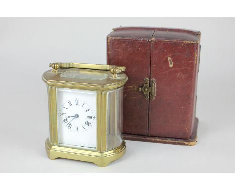 A brass and glass cased semi oval carriage clock, the white enamel dial with Roman  numerals, the movement stamped France, 9c