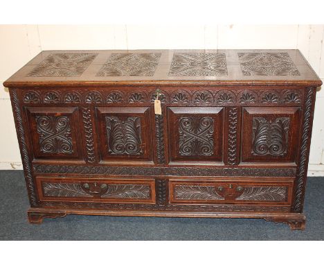 A 19th century carved oak four-panel mule chest with foliate and floral decoration and two frieze drawers, raised on bracket 