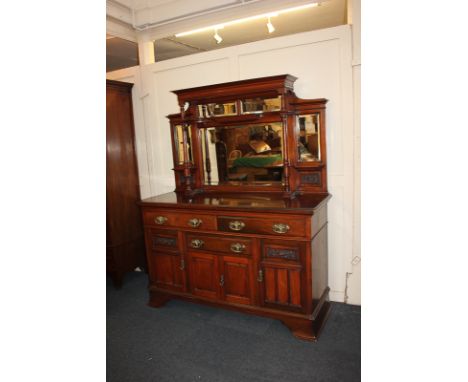 A Victorian style sideboard with raised panelled mirror back and turned supports above an arrangement of three drawers and cu