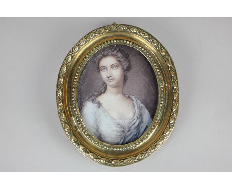 A 19th century painted miniature portrait of a young lady with brown  hair and blue eyes, on porcelain, 9cm by 6.5cm